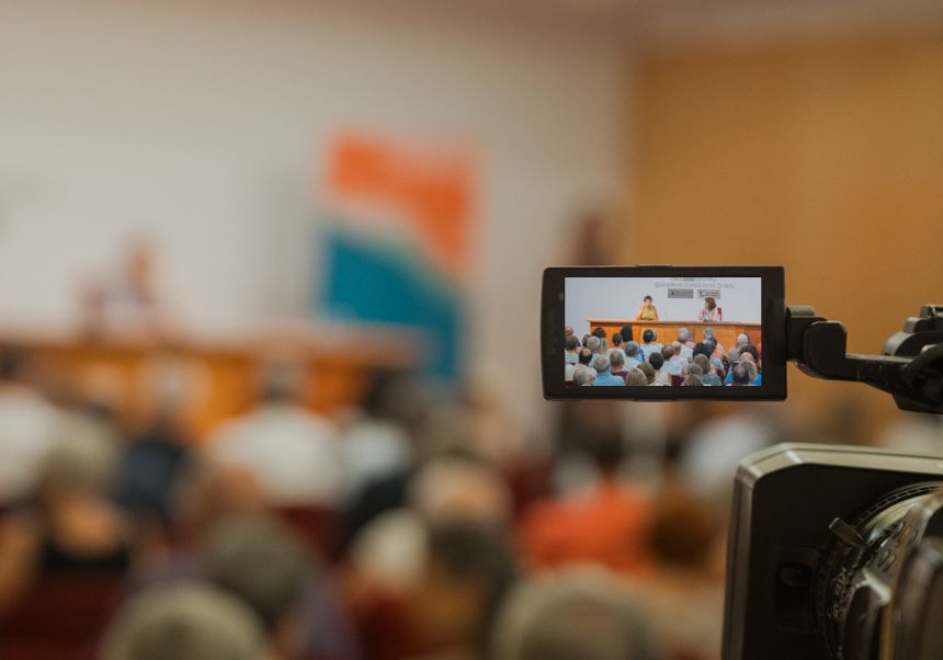 Una càmera entre el públic enfoca al conferenciant a la 42 UEG